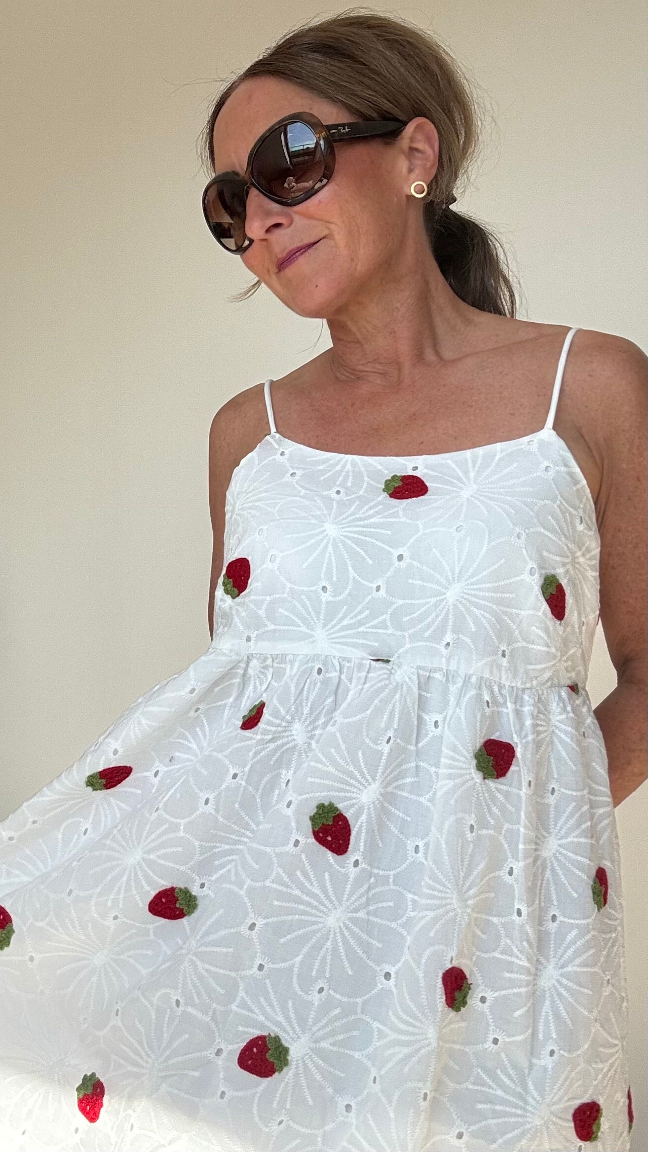 Sommerliches Maxi-Kleid Strawberry Summerdream aus weißer Baumwolle mit zarter Broderie Anglaise und gehäkelten Erdbeer-Motiven. Das Kleid hat verstellbare Spaghetti-Träger, einen seitlichen Reißverschluss und ist leicht unterfüttert. Länge ca. 137 cm, passt ideal für Größe 34–38. Perfekt für warme Tage, Gartenpartys oder den Urlaub.