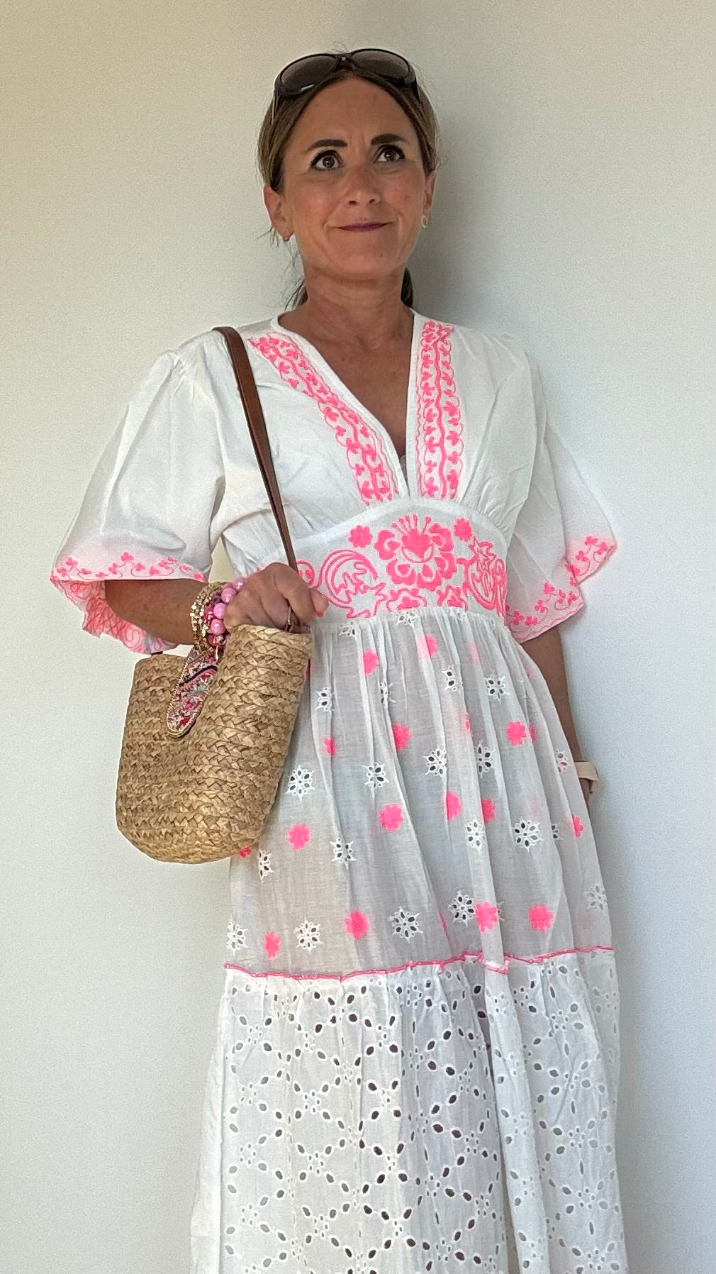 Sommerliches Maxikleid Boho Breeze Dress – White Edition aus weißer Baumwolle mit pinkfarbener Stickerei. Luftiger Stufenschnitt mit kurzen Ärmeln, V-Ausschnitt und elastischem Rückenbund. Länge ca. 133 cm, passt locker von Größe 36–40. Nicht unterfüttert – ideal für heiße Tage oder mit Unterkleid tragbar.