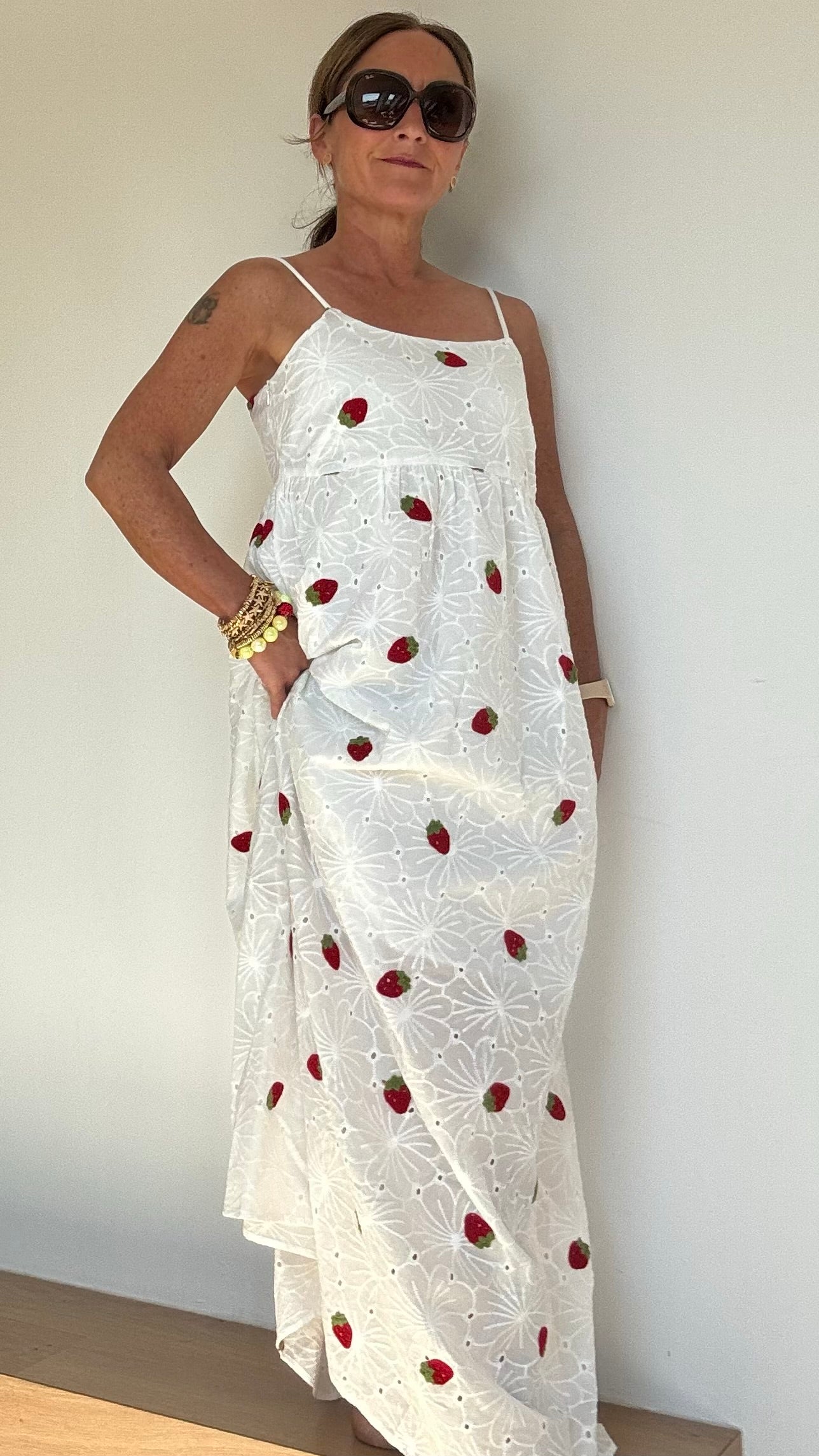 Sommerliches Maxi-Kleid Strawberry Summerdream aus weißer Baumwolle mit zarter Broderie Anglaise und gehäkelten Erdbeer-Motiven. Das Kleid hat verstellbare Spaghetti-Träger, einen seitlichen Reißverschluss und ist leicht unterfüttert. Länge ca. 137 cm, passt ideal für Größe 34–38. Perfekt für warme Tage, Gartenpartys oder den Urlaub.