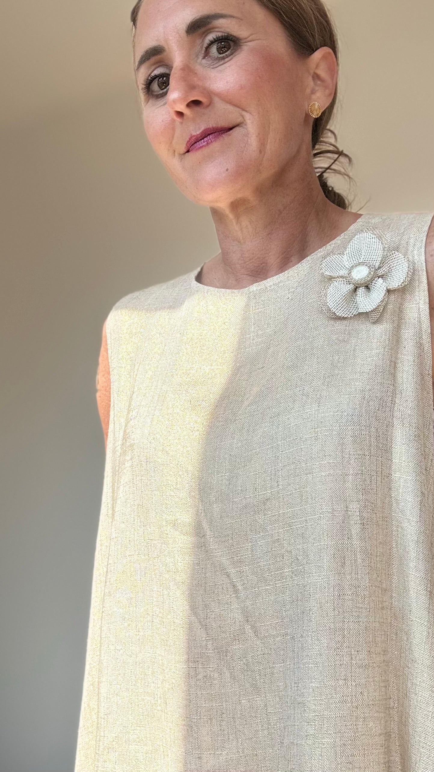 Ärmelloses Sommerkleid „Golden Glow“ in edlem Goldton. A-Linien-Schnitt mit 93 cm Länge, tiefen Armausschnitten und Rundhalsausschnitt mit Knopfverschluss hinten. Hergestellt aus leichtem Rayon-Leinen-Mix. Verziert mit abnehmbarer, goldener Blumenbrosche. Passend für Größen 34–38. Ideal für elegante Sommeranlässe.