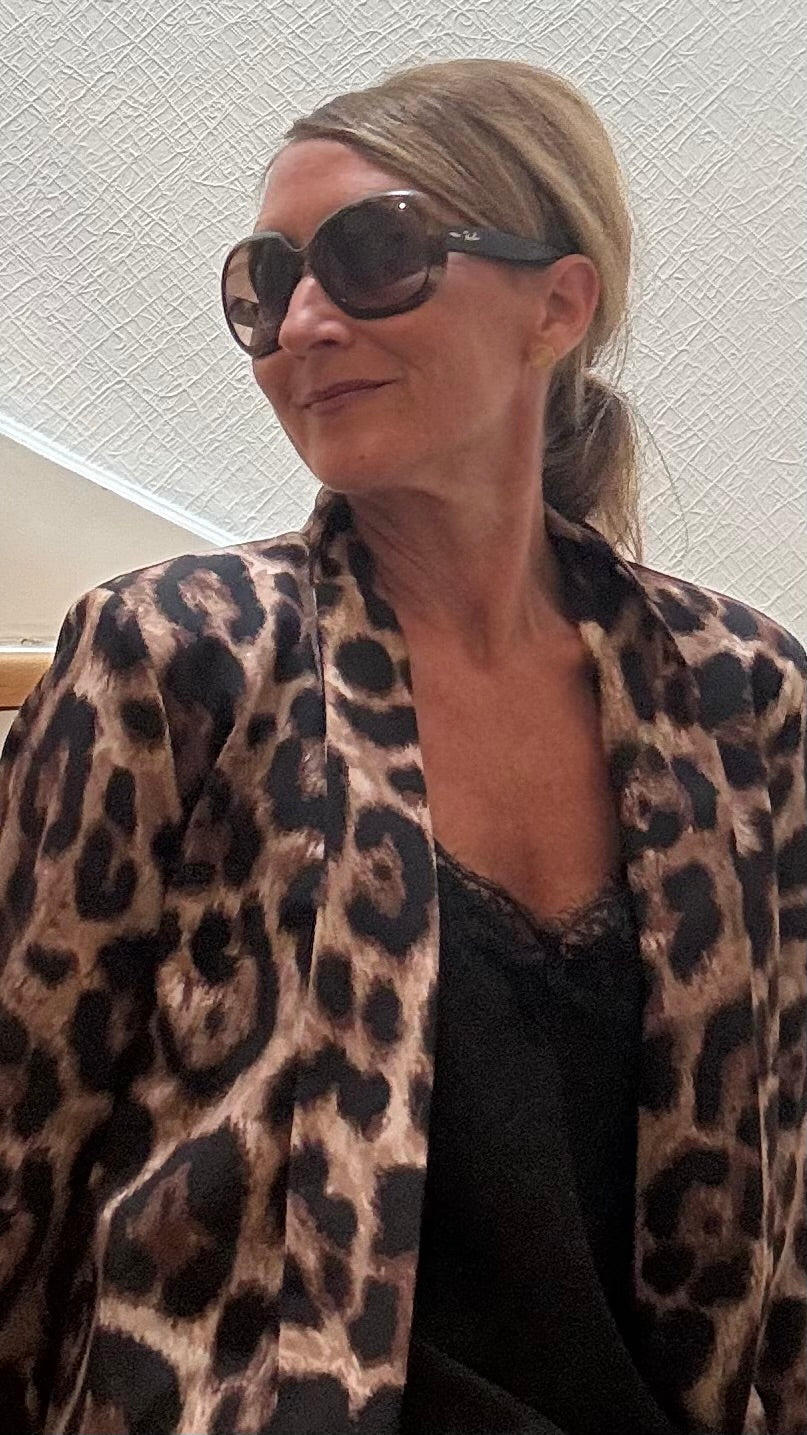 Leichter Oversize-Blazer im dunklen Leo-Print mit schwarzem Futter. Offener Schnitt, gekrempelte Ärmel, Länge ca. 72 cm – vielseitig kombinierbar.