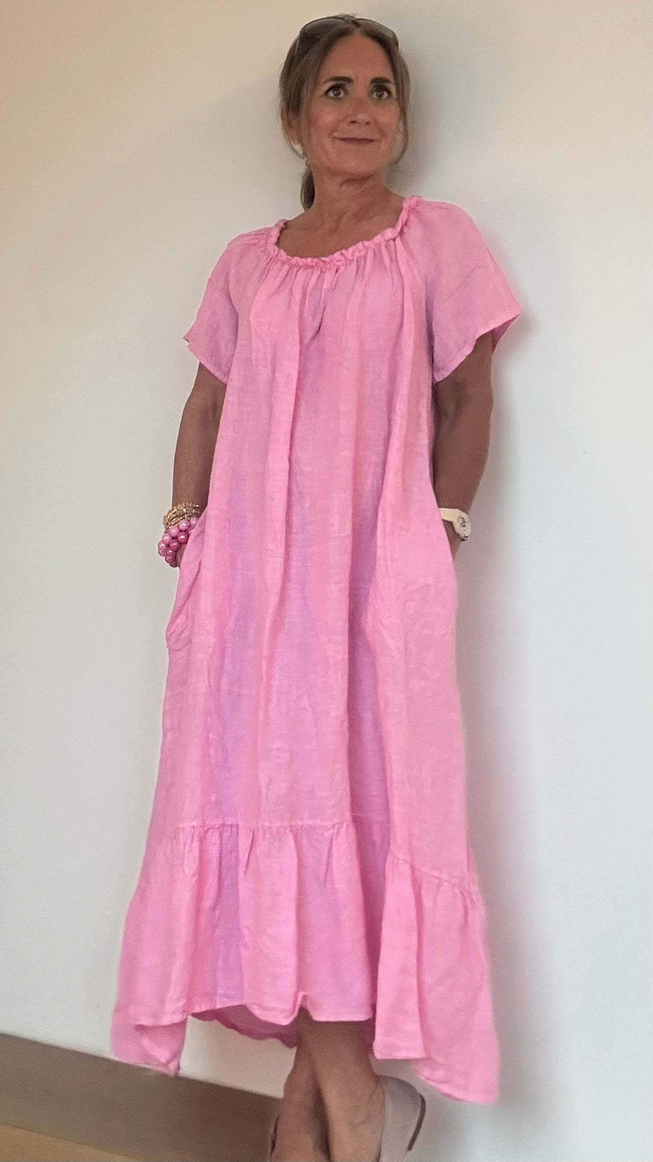 Kurzärmliges Leinenkleid mit elastischem Halsausschnitt und Volant-Abschluss, gerade und luftig geschnitten. Länge vorne 110 cm, hinten leicht verlängert. Mit Eingriffstaschen und vielseitig tragbar – klassisch oder als Carmenkleid. Figurumspielend und ideal für Petite-Frauen. Aus 100 % Leinen für sommerlichen Komfort.