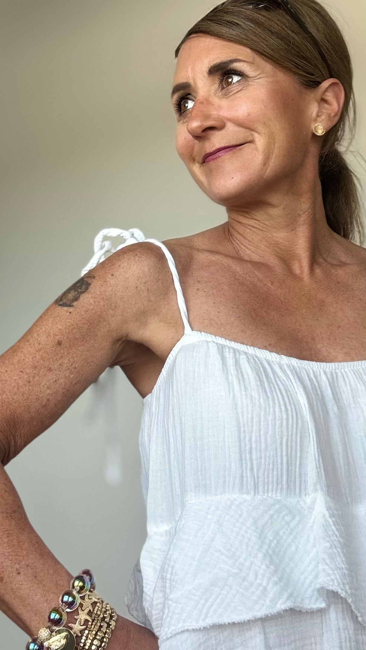 Luftiges Sommerkleid aus weichem Musselin in Weiß mit verstellbaren Spaghettiträgern und elastischem Ausschnitt. Das Kleid fällt locker und ist vorn etwas kürzer geschnitten als hinten. Drei Volantstufen sorgen für Bewegung und femininen Schwung. Perfekt kombinierbar mit Sandalen, Sneakers oder Ballerinas – ideal für warme Tage in der Stadt, am Strand oder auf der Sommerparty. Länge ca. 132 cm, passt locker von Größe 34–42, auch für Petite geeignet.