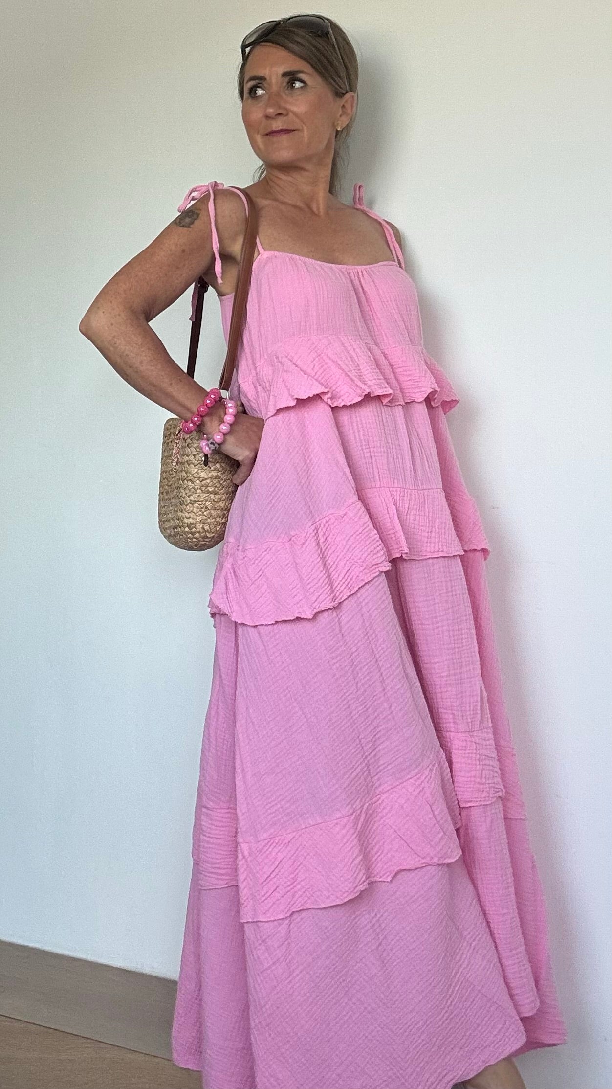 Luftiges Sommerkleid aus weichem Musselin in Weiß mit verstellbaren Spaghettiträgern und elastischem Ausschnitt. Das Kleid fällt locker und ist vorn etwas kürzer geschnitten als hinten. Drei Volantstufen sorgen für Bewegung und femininen Schwung. Perfekt kombinierbar mit Sandalen, Sneakers oder Ballerinas – ideal für warme Tage in der Stadt, am Strand oder auf der Sommerparty. Länge ca. 132 cm, passt locker von Größe 34–42, auch für Petite geeignet.