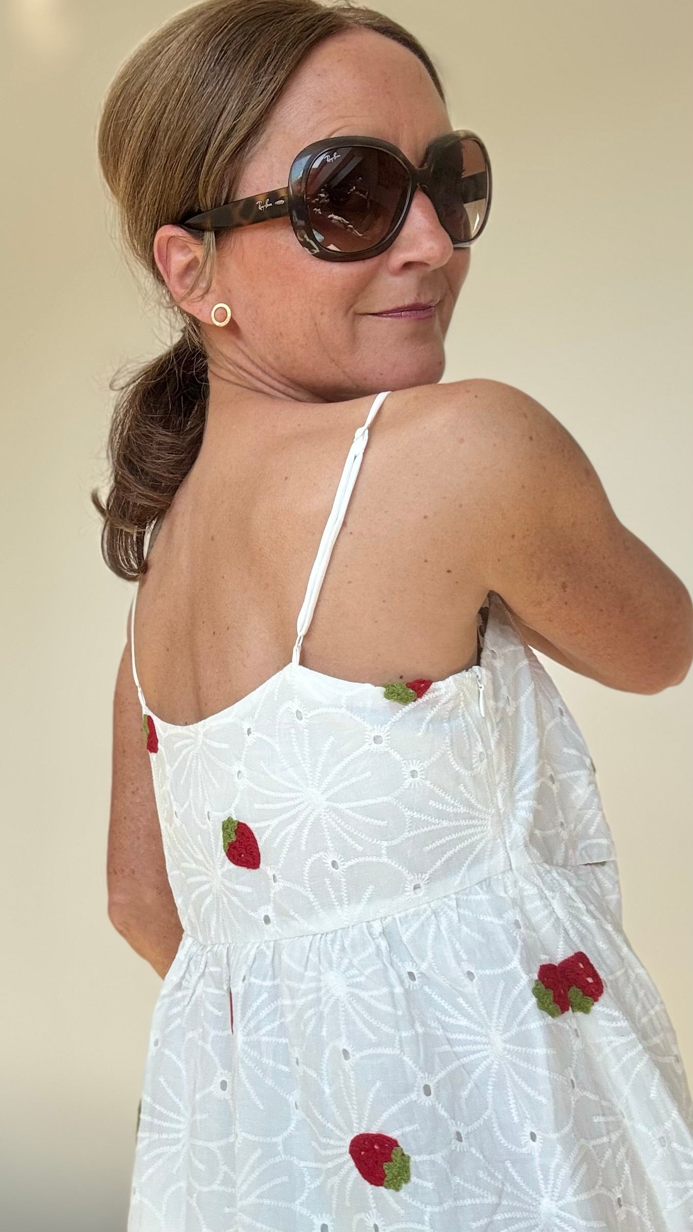 Sommerliches Maxi-Kleid Strawberry Summerdream aus weißer Baumwolle mit zarter Broderie Anglaise und gehäkelten Erdbeer-Motiven. Das Kleid hat verstellbare Spaghetti-Träger, einen seitlichen Reißverschluss und ist leicht unterfüttert. Länge ca. 137 cm, passt ideal für Größe 34–38. Perfekt für warme Tage, Gartenpartys oder den Urlaub.