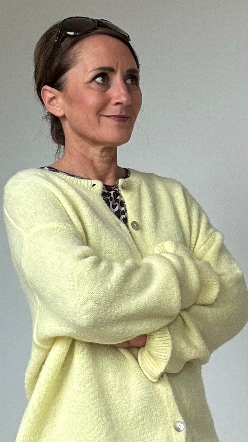 Ruffle Grace Cardigan in lockerer Passform mit einer Länge von ca. 58 cm. Gefertigt aus 30 % Alpaka, 30 % Polyamid, 20 % Polyacryl, 17 % Wolle und 3 % Elastan. Der Cardigan hat einen Rundhalsausschnitt, lange Ärmel mit besonderen Strick-Rüschen an den Bündchen und Perlmuttknöpfe. Geeignet für Größen 34-42, ideal für feminine und vielseitige Looks. Kombinierbar mit Jeans, Röcken oder Kleidern für elegante und lässige Outfits