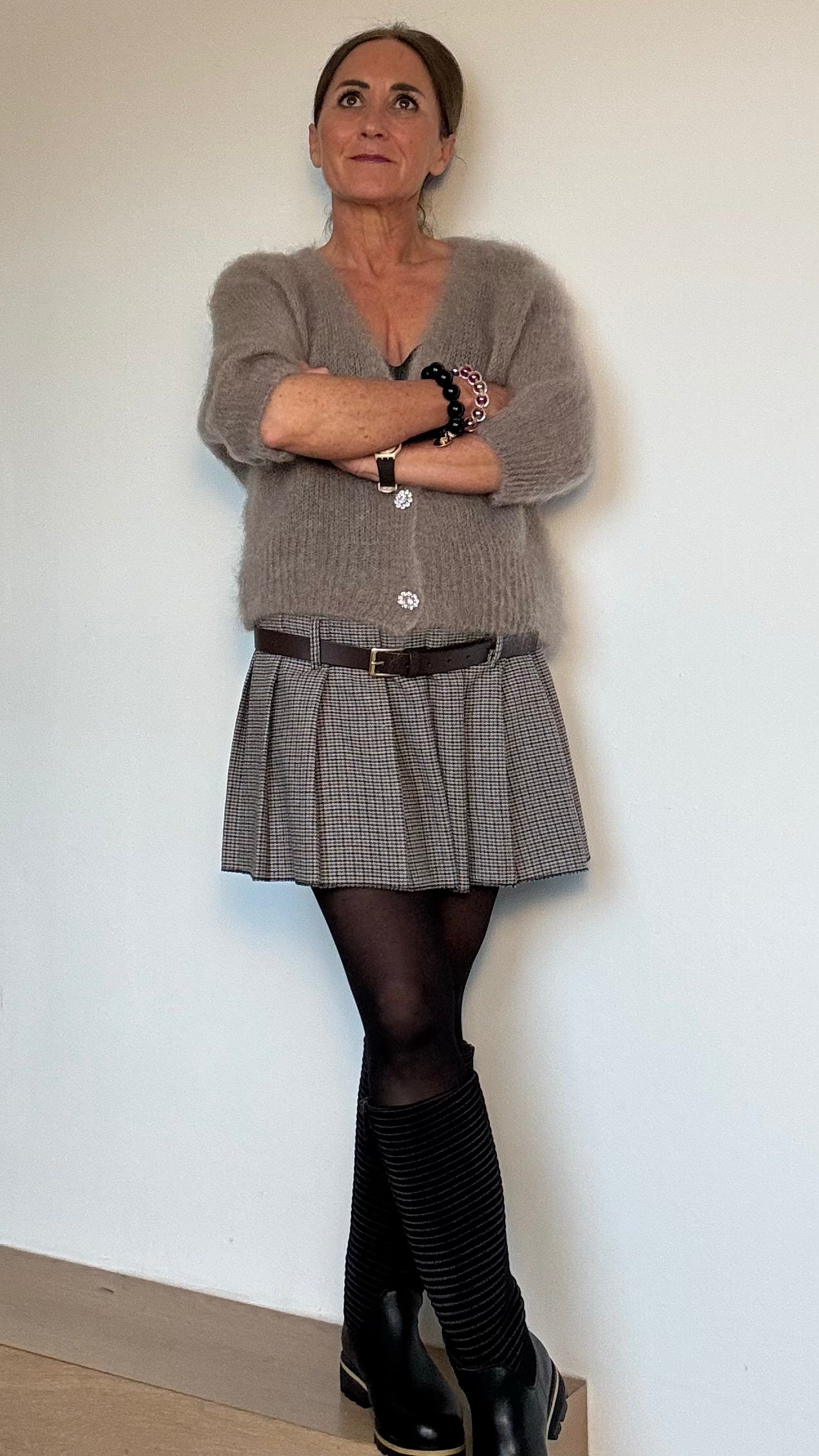 Minirock im Pepita-Muster in klassischen Beige-Braun-Tönen. Auf der Hüfte getragen, mit Ziergürtel, Faltenlegung und seitlichem Reißverschluss. Hochwertige Wollmischung, vielseitig kombinierbar.