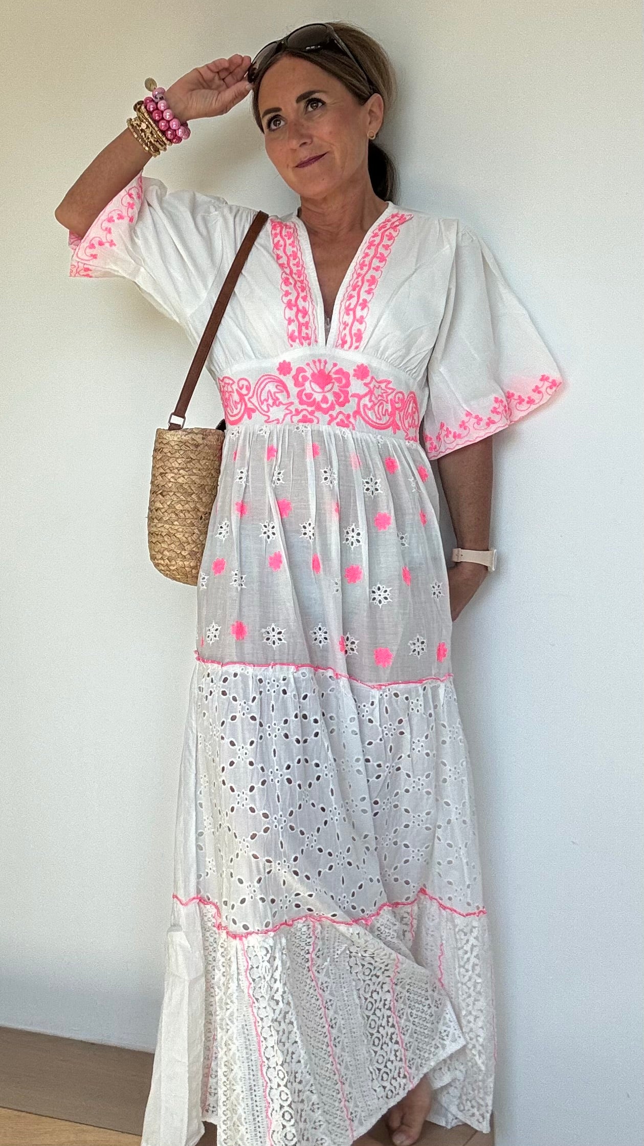 Sommerliches Maxikleid Boho Breeze Dress – White Edition aus weißer Baumwolle mit pinkfarbener Stickerei. Luftiger Stufenschnitt mit kurzen Ärmeln, V-Ausschnitt und elastischem Rückenbund. Länge ca. 133 cm, passt locker von Größe 36–40. Nicht unterfüttert – ideal für heiße Tage oder mit Unterkleid tragbar.