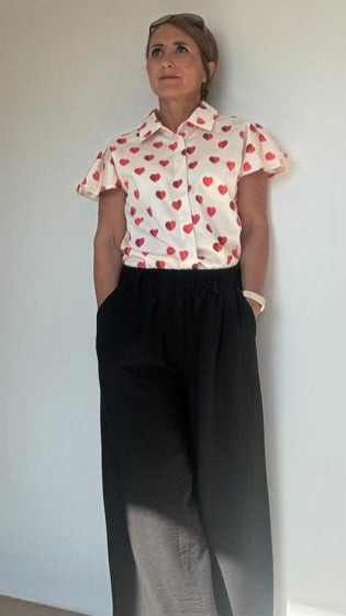 Bluse von Designerin Marianna Déri aus Düsseldorf mit niedlichen, zweifarbigen Herzen und stilvollen Flügelärmeln. Die Bluse hat einen breiten Kragen und eine verdeckte Knopfleiste für ein elegantes Styling. Hergestellt aus 97% Baumwolle und 3% Elasthan für Komfort und Passform. Perfekt für Büro, Wochenende oder Dates. Größe S: Brustumfang 88 cm, Taille 70 cm.