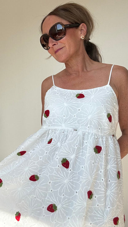 Sommerliches Maxi-Kleid Strawberry Summerdream aus weißer Baumwolle mit zarter Broderie Anglaise und gehäkelten Erdbeer-Motiven. Das Kleid hat verstellbare Spaghetti-Träger, einen seitlichen Reißverschluss und ist leicht unterfüttert. Länge ca. 137 cm, passt ideal für Größe 34–38. Perfekt für warme Tage, Gartenpartys oder den Urlaub.