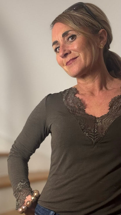 Feminines Basicshirt aus Kaschmirblend mit V-Ausschnitt und feiner Spitze an Ausschnitt und Ärmelabschluss. Weich, elastisch und leicht transparent. Figurumspielender Schnitt, Länge ca. 59 cm. Erhältlich in Schwarz, Schoko und Burgundy.