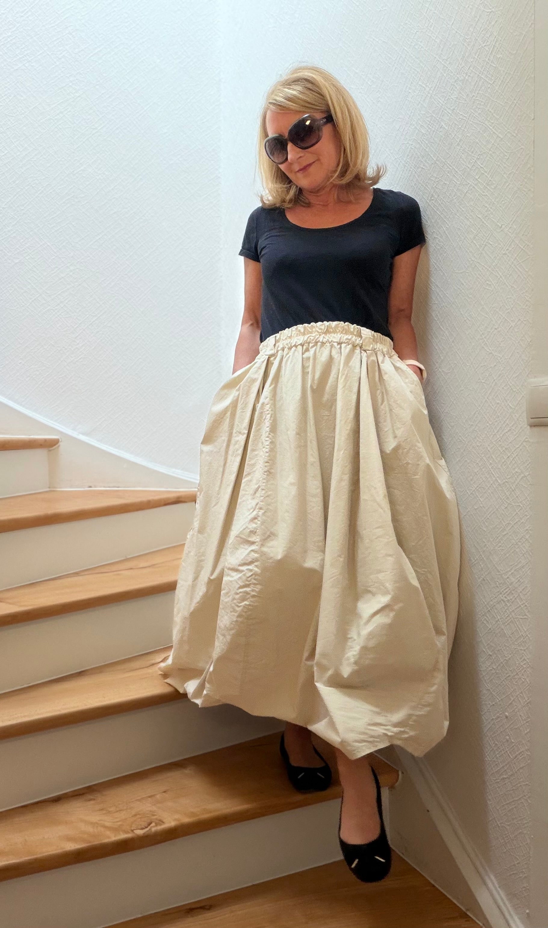 Voluminöser Baumwollrock mit elastischem Bund, Gürtelschlaufen und unregelmäßigem Saum. Locker fallend mit Eingriffstaschen und besonderer Silhouette.