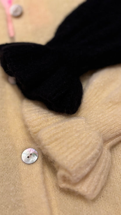 Auf diesem Bild werden die Strickrüschenabschlüsse am Ärmelbündchen gezeigt in den beiden FArbvarianten schwarz und hellgelb.