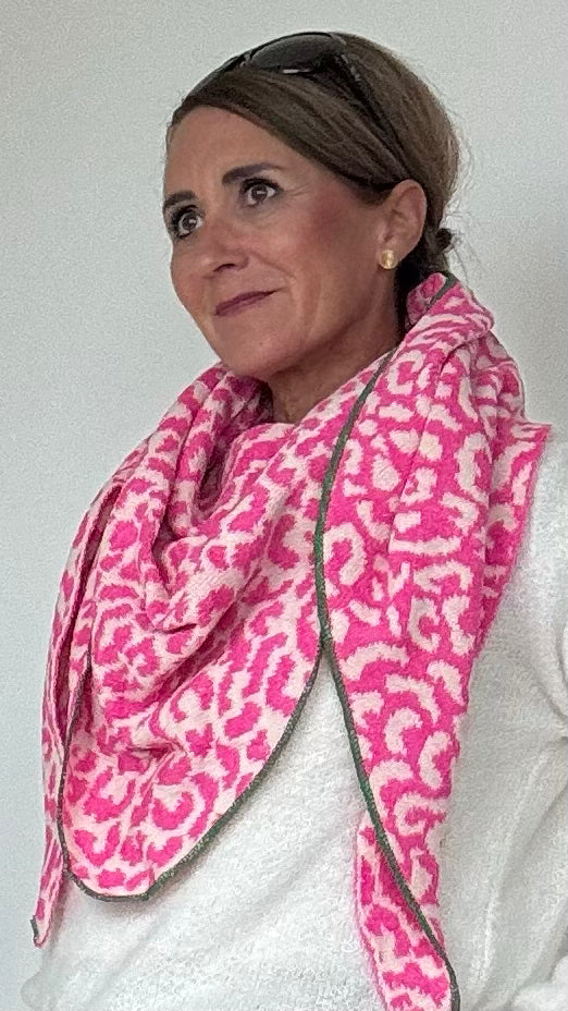 Großes Strick-Dreieckstuch mit Leo-Muster und farblich abgesetztem Rand. Variante 1: Anthrazit mit Wollweiß für einen klassischen Look. Variante 2: Neonpink mit Wollweiß für einen auffälligen Akzent. Weiches, dichtes Strickmaterial, lässig über den Schultern getragen.
