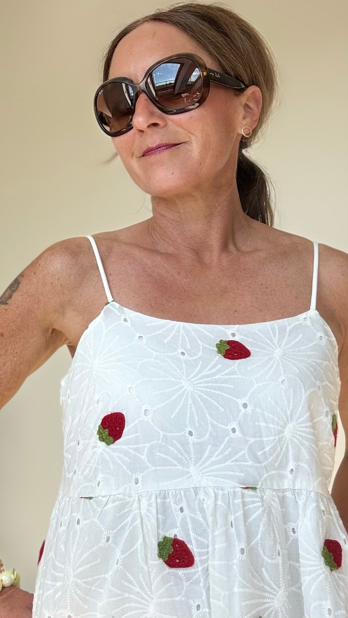 Sommerliches Maxi-Kleid Strawberry Summerdream aus weißer Baumwolle mit zarter Broderie Anglaise und gehäkelten Erdbeer-Motiven. Das Kleid hat verstellbare Spaghetti-Träger, einen seitlichen Reißverschluss und ist leicht unterfüttert. Länge ca. 137 cm, passt ideal für Größe 34–38. Perfekt für warme Tage, Gartenpartys oder den Urlaub.