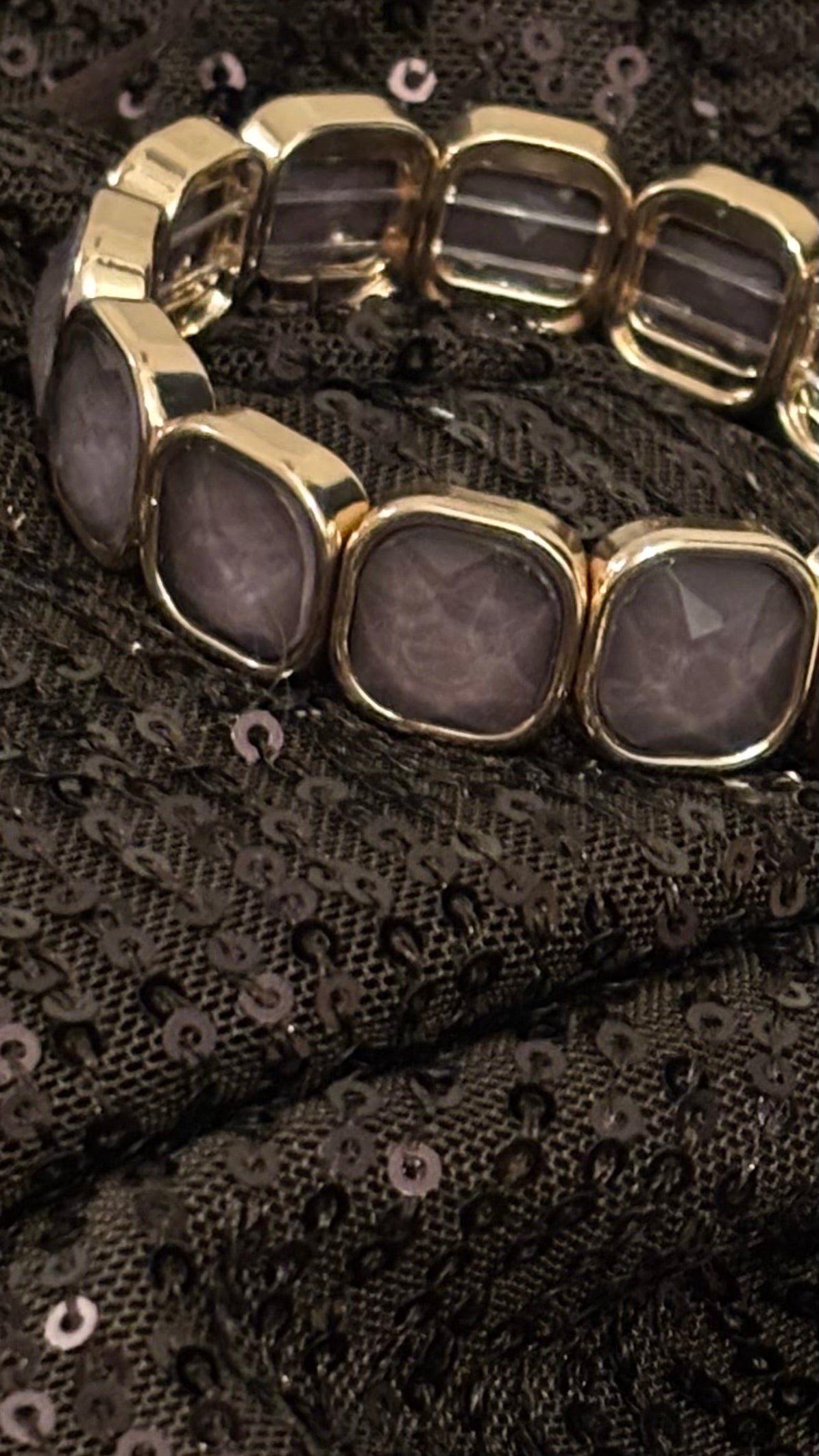 Kristallarmband mit 13 facettierten Steinen in Greige/Taupe-Grau und goldfarbener Fassung. Schlankes, elegantes, elastisches Design.