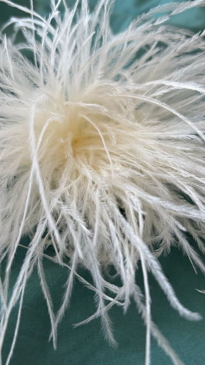 Zarte Brosche aus feinen Federn in Ecru, flexibel tragbar als Anstecker oder Haarclip. Luftiges, extravagantes Accessoire für schlichte Outfits oder besondere Anlässe.