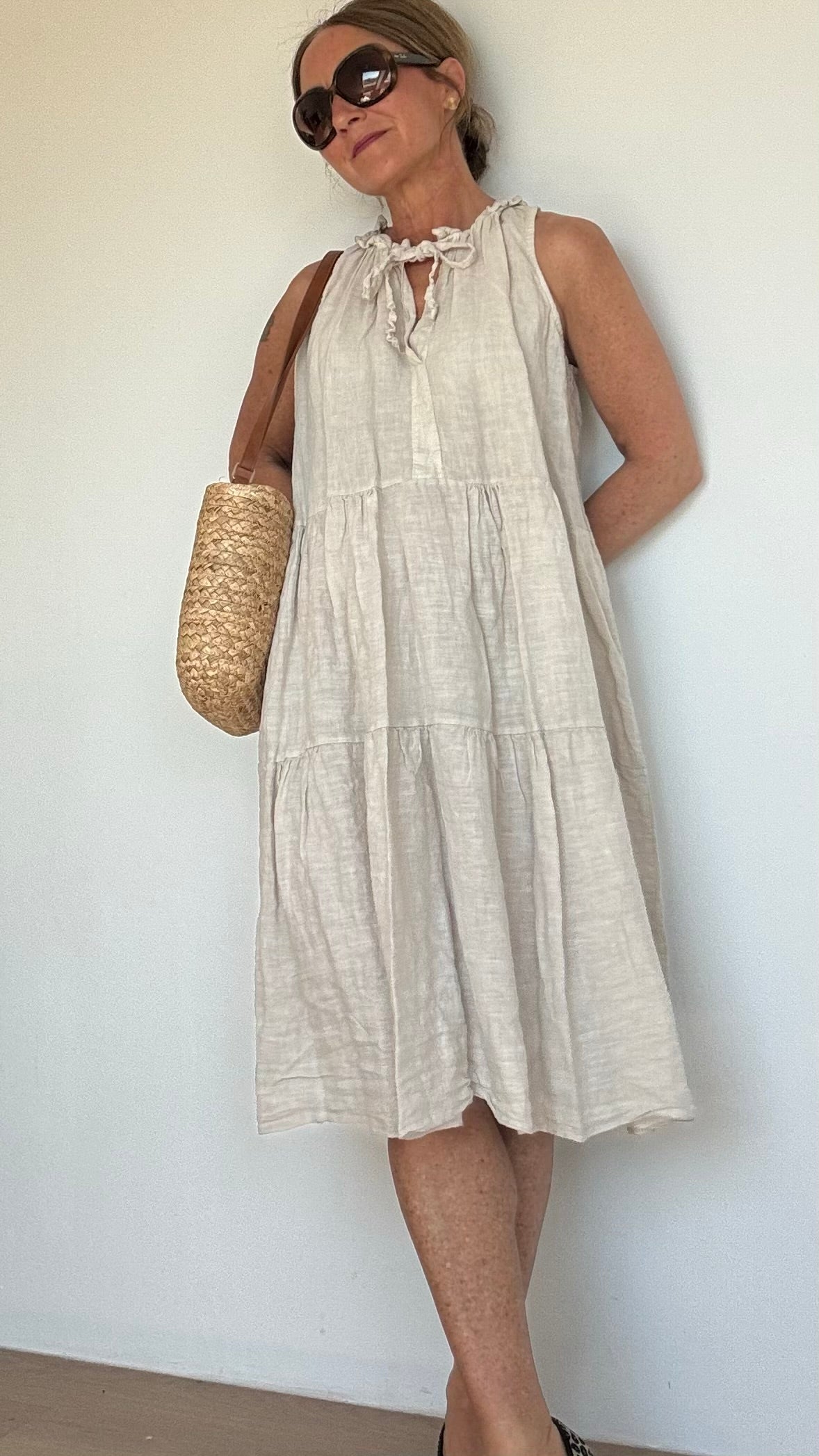 Midi-Kleid aus 100% Leinen mit A-Linien-Schnitt und elastischem V-Ausschnitt, der gebunden oder offen getragen werden kann. Schlichtes Design für Büro, Abend oder besondere Anlässe. Ideal für Größen 34-40, Länge: 94 cm.

