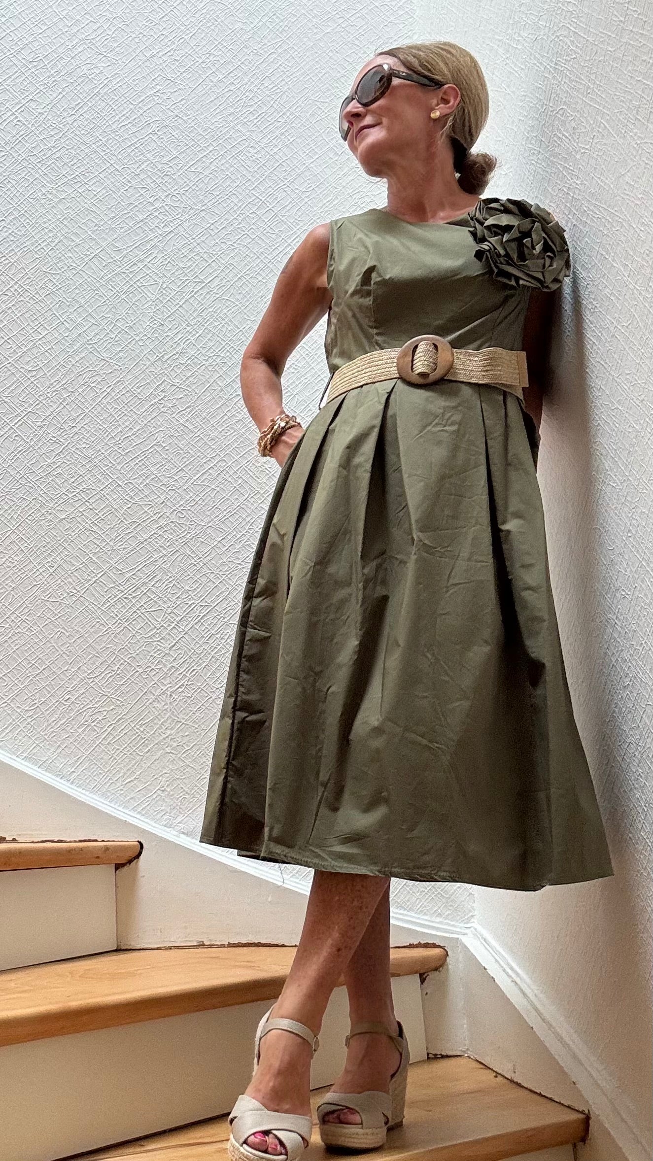 Olivfarbenes Baumwollkleid mit elastischem Taillenbereich und großer Kamelien-Brosche – Camellia Charm Dress von Miss Lotti.

