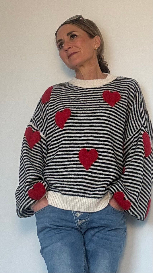 Gestreifter Strickpullover in Schwarz-Wollweiß oder Hellrosa-Weiß mit roten Herz-Applikationen. Ballonärmel, Oversize-Passform, ideal für Layering. Passt von Größe 34 bis 42. Material: Acryl, Polyamid, Wolle und Viskose