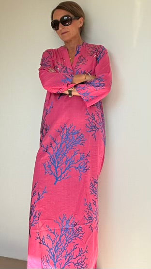 Pinke Strandkleid von Isla Bonita by Sigris mit leuchtend blauem Korallenmuster. Gesamtlänge 140 cm, seitliche Beinschlitze für eine elegante Note. Größe S (36): Brustweite 84-86 cm, Taille 74-80 cm, Hüfte 94-98 cm. Größe M (38-40): Brustweite 90-92 cm, Taille 80-86 cm, Hüfte 98-102 cm. Ideal für Frauen ca. 1,60 cm und größer. 100% Baumwolle, perfekt für Strand und Pool