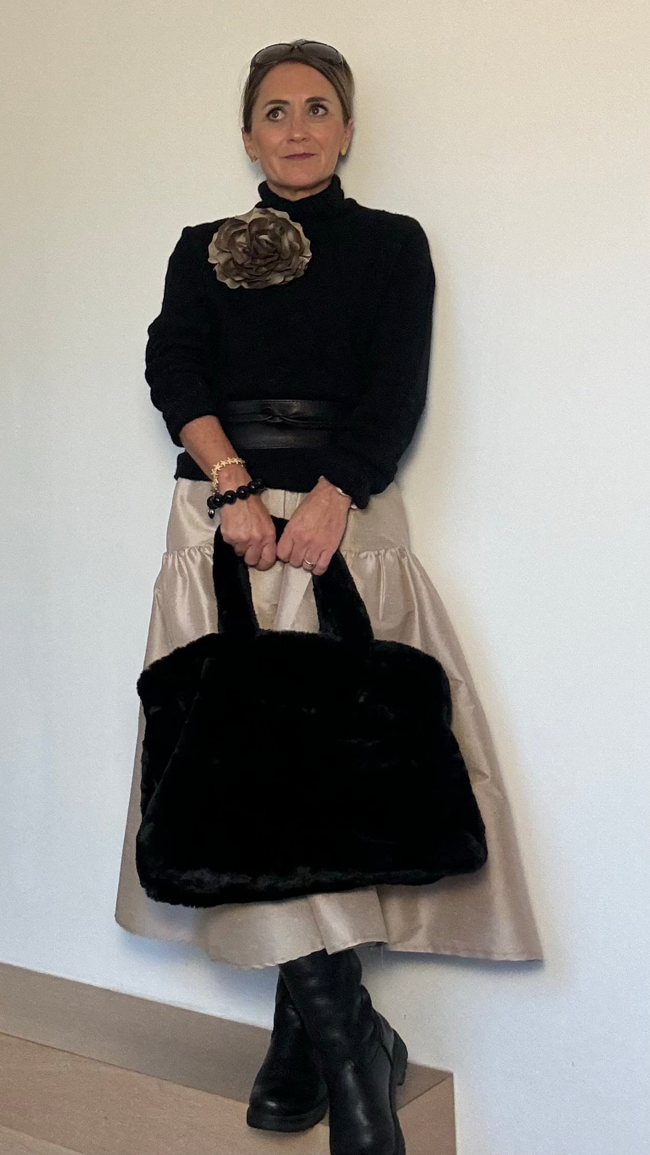 Schwarzer Faux-Fur-Shopper mit Reißverschluss und zwei abnehmbaren Bommel. Rechteckige Form mit zusätzlichem Tragegurt für Schulter oder Crossbody. Weiches, plüschiges Material mit dezentem Glanz.