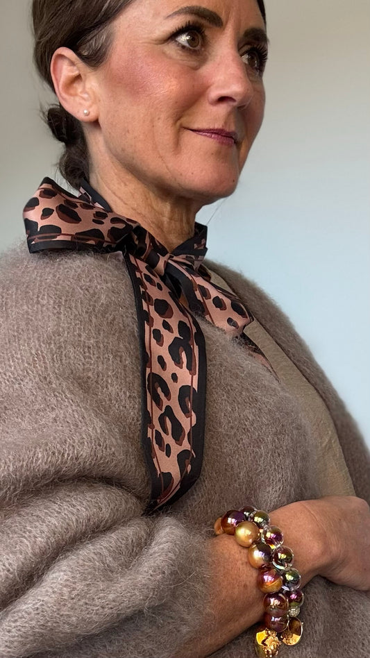 Leo-Band aus 100% Viskose, Länge 157 cm, Breite 5 cm, in hellem und dunklem Leo-Print. Spitz zulaufende Enden für vielseitige Stylingmöglichkeiten: als Halsband, Gürtel, Haarband oder Accessoire für Taschen.

