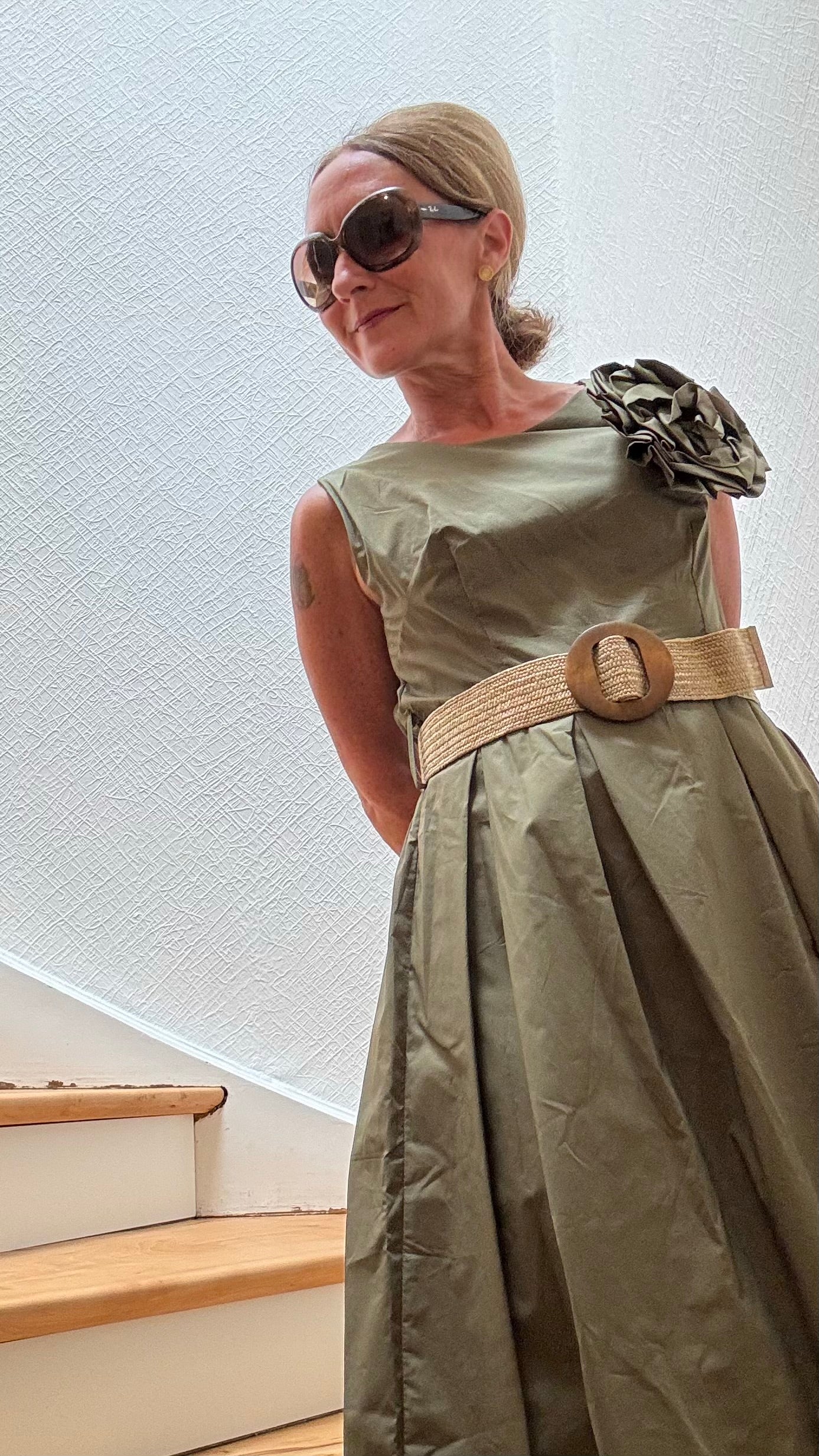 Olivfarbenes Baumwollkleid mit elastischem Taillenbereich und großer Kamelien-Brosche – Camellia Charm Dress von Miss Lotti.

