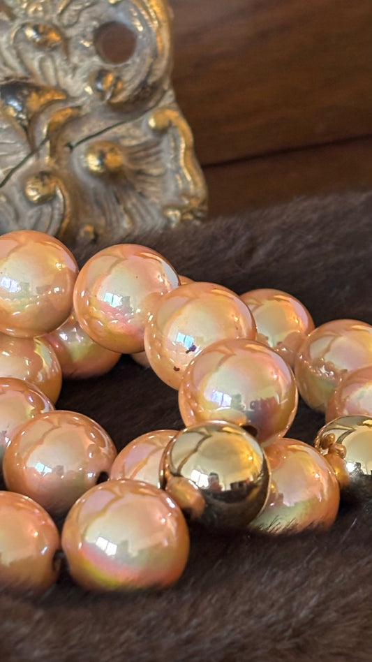 Perlenarmband mit apricotfarbenen 20-mm-Perlen in Perlmutt-Metallic und goldener Akzentperle. Warm schimmernder Apricot-Golden-Glow.