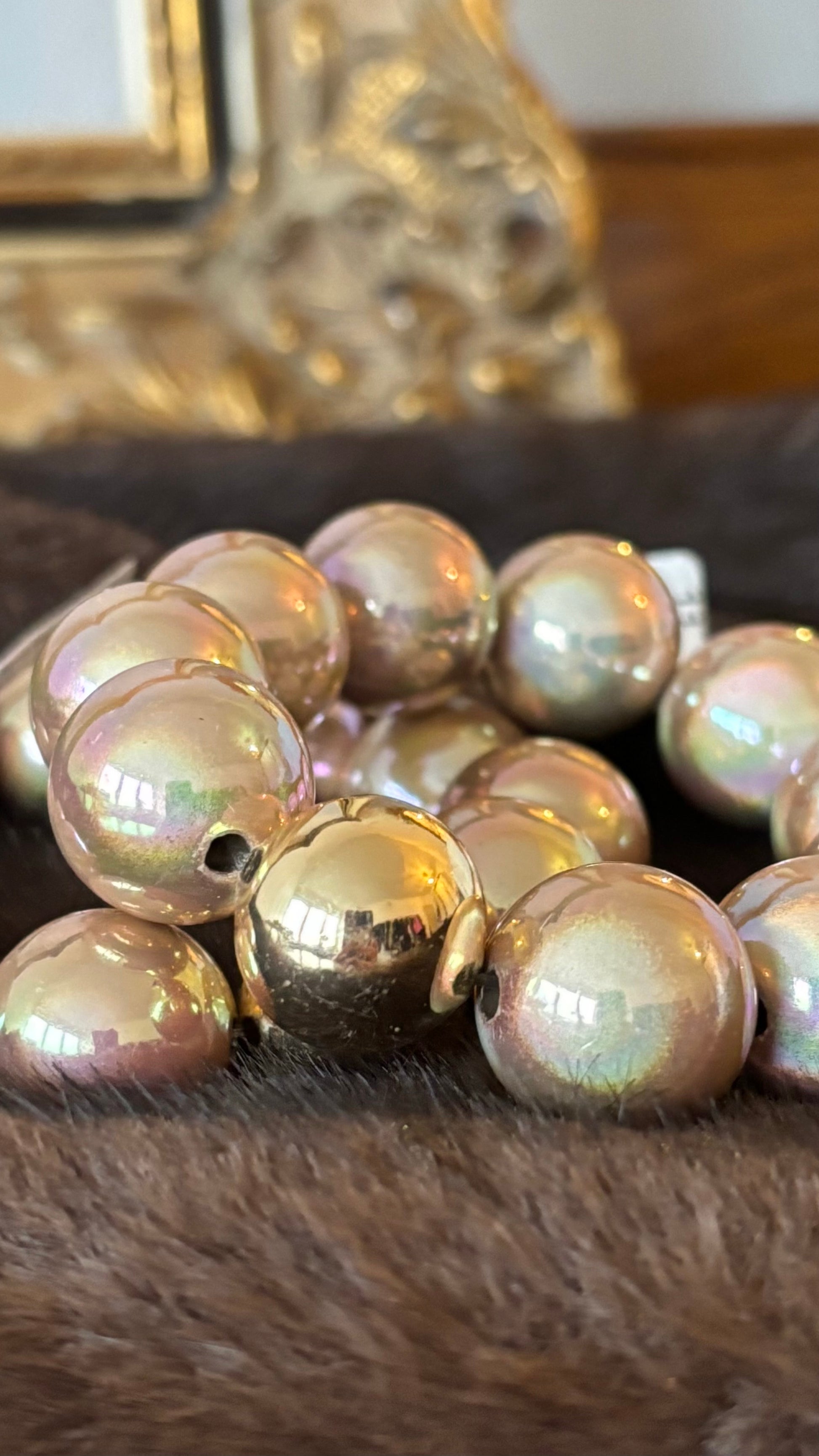 Champagnerfarbenes Perlenarmband mit großen, glatt polierten Perlen in 20 mm und einer goldenen Akzentperle. Glänzender Schimmer mit Rosé-, Pfirsich- und Apricot-Nuancen.