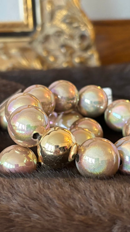 Champagnerfarbenes Perlenarmband mit großen, glatt polierten Perlen in 20 mm und einer goldenen Akzentperle. Glänzender Schimmer mit Rosé-, Pfirsich- und Apricot-Nuancen.