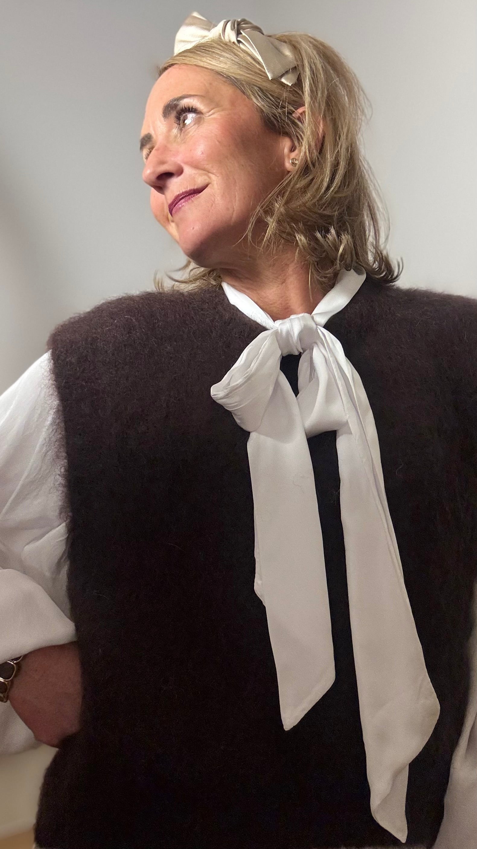 Pullunder aus Kid-Mohair in der Farbe Schoko mit klassischem Rundhalsausschnitt und tiefen Armausschnitten. Locker geschnittener, kurzer Pullunder mit weicher, flauschiger Oberfläche, ideal für Layering-Looks. Getragen über einem schlichten Outfit in warmen Naturtöne