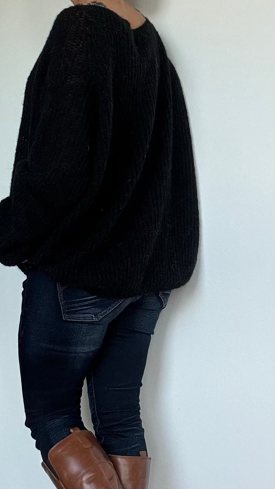 Schwarzer Oversize-Pullover aus superfeinem Alpaka, gestrickt im Patentmuster. Der Pullover hat einen weiten U-Boot-Ausschnitt, überschnittene Schultern und eine Länge von 63 cm. Die großzügige Passform (Achsel zu Achsel: 78 cm) passt von Größe 34 bis 42. Dank des federleichten, hauchzarten Materials ist er ideal für alle Jahreszeiten. Perfekt für Layering-Looks: Kombiniert mit einem Top, das leicht hervorblitzt, oder leger über Jeans getragen. Zeitloses Schwarz für vielseitige, stilvolle Outfits. 