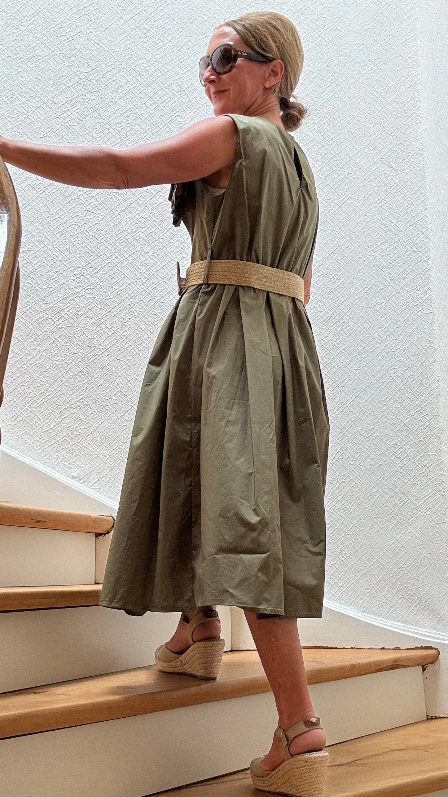 Olivfarbenes Baumwollkleid mit elastischem Taillenbereich und großer Kamelien-Brosche – Camellia Charm Dress von Miss Lotti.

