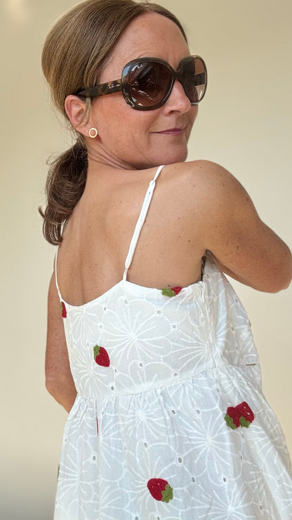 Sommerliches Maxi-Kleid Strawberry Summerdream aus weißer Baumwolle mit zarter Broderie Anglaise und gehäkelten Erdbeer-Motiven. Das Kleid hat verstellbare Spaghetti-Träger, einen seitlichen Reißverschluss und ist leicht unterfüttert. Länge ca. 137 cm, passt ideal für Größe 34–38. Perfekt für warme Tage, Gartenpartys oder den Urlaub.