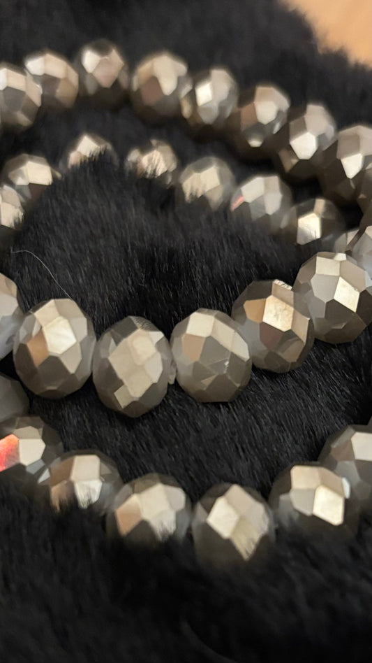 Armband mit ca. 22 taupefarbenen, facettierten Glasperlen (8 mm) auf elastischem Band. Subtiler Glow durch feinen Facettenschliff.