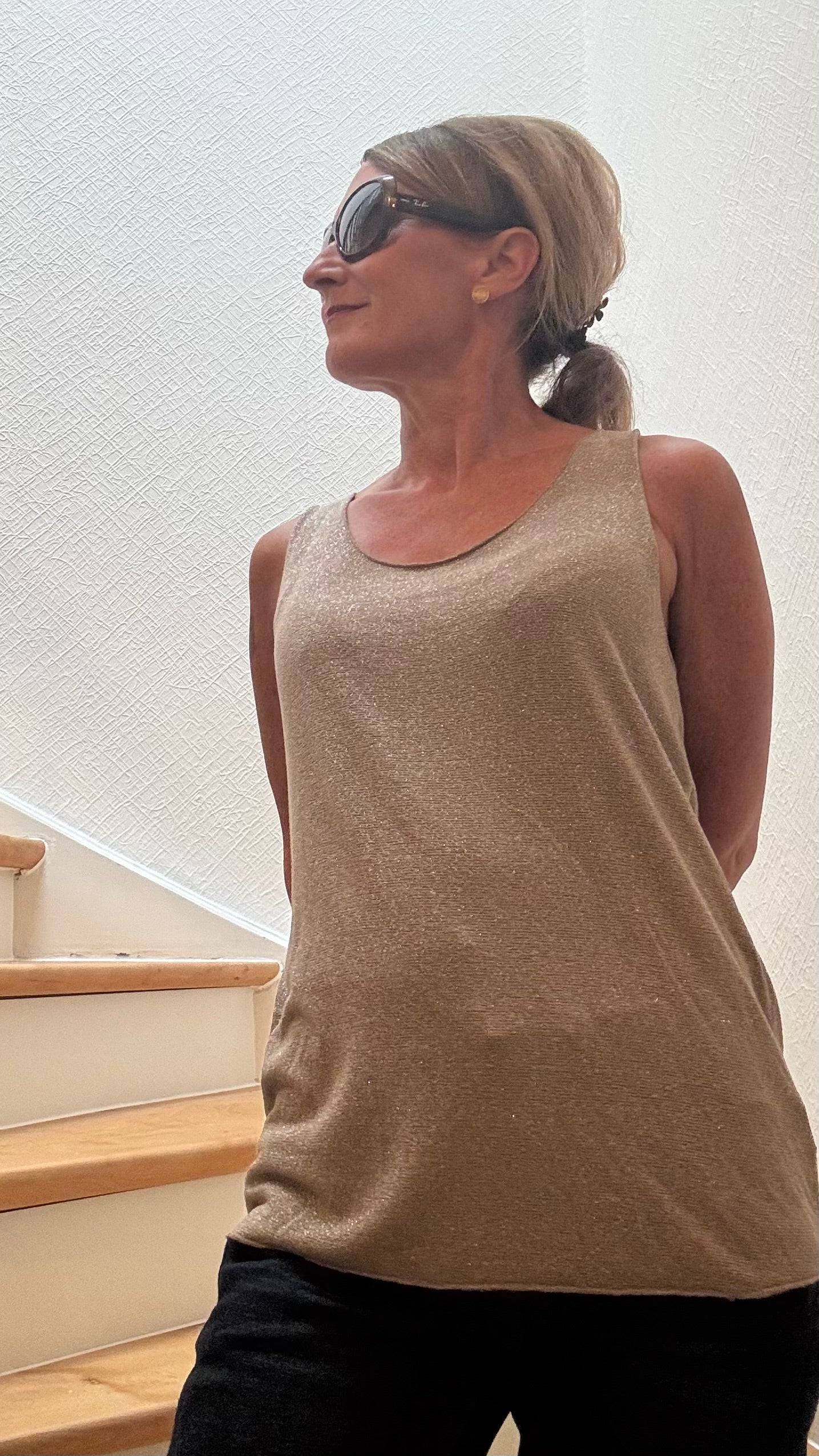 Shimmer Touch Top aus zartem Jersey mit eingewebtem Silbergarn. 95 % Viskose, 5 % Elasthan. Länge ca. 64 cm, Achsel zu Achsel 50 cm. In Beige mit goldenem Schimmer und Schwarz mit Silber. Figurbetont, vielseitig kombinierbar.