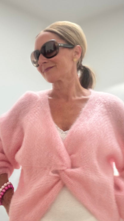 Leichter Kid-Mohair-Pullover Twist & Cozy in verschlungenem Design, vorne kürzer geschnitten, in Hellrosa, getragen über einem Sommerkleid.