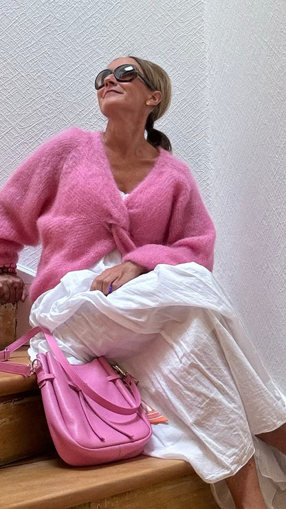 Leichter Kid-Mohair-Pullover Twist & Cozy in verschlungenem Design, vorne kürzer geschnitten, in Cremefarbe, getragen über einem Sommerkleid.