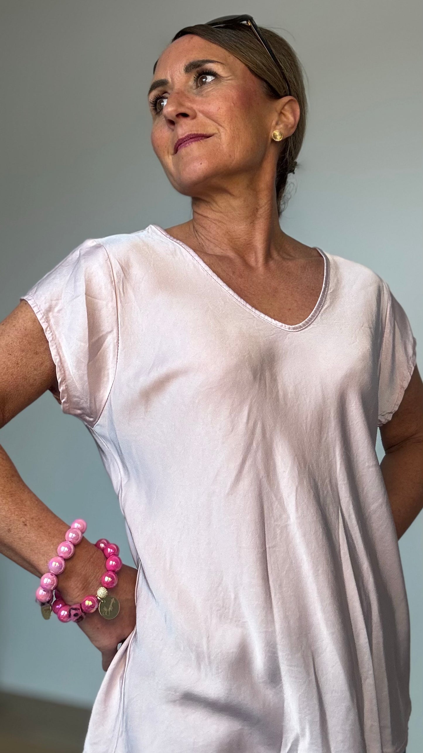 Fließendes Oberteil aus 100% Viskose mit dezentem Glanz. Die Satin Glow Blouse hat kurze Ärmel, einen sanften V-Ausschnitt vorne und hinten und eine luftige Passform. Mit einer Länge von ca. 62 cm und einer Breite von ca. 50 cm passt sie schmalen Kleidergrößen 34–40. Perfekt kombinierbar mit Jeans, Röcken, Cardigans und Blazern für einen stilvollen Look.