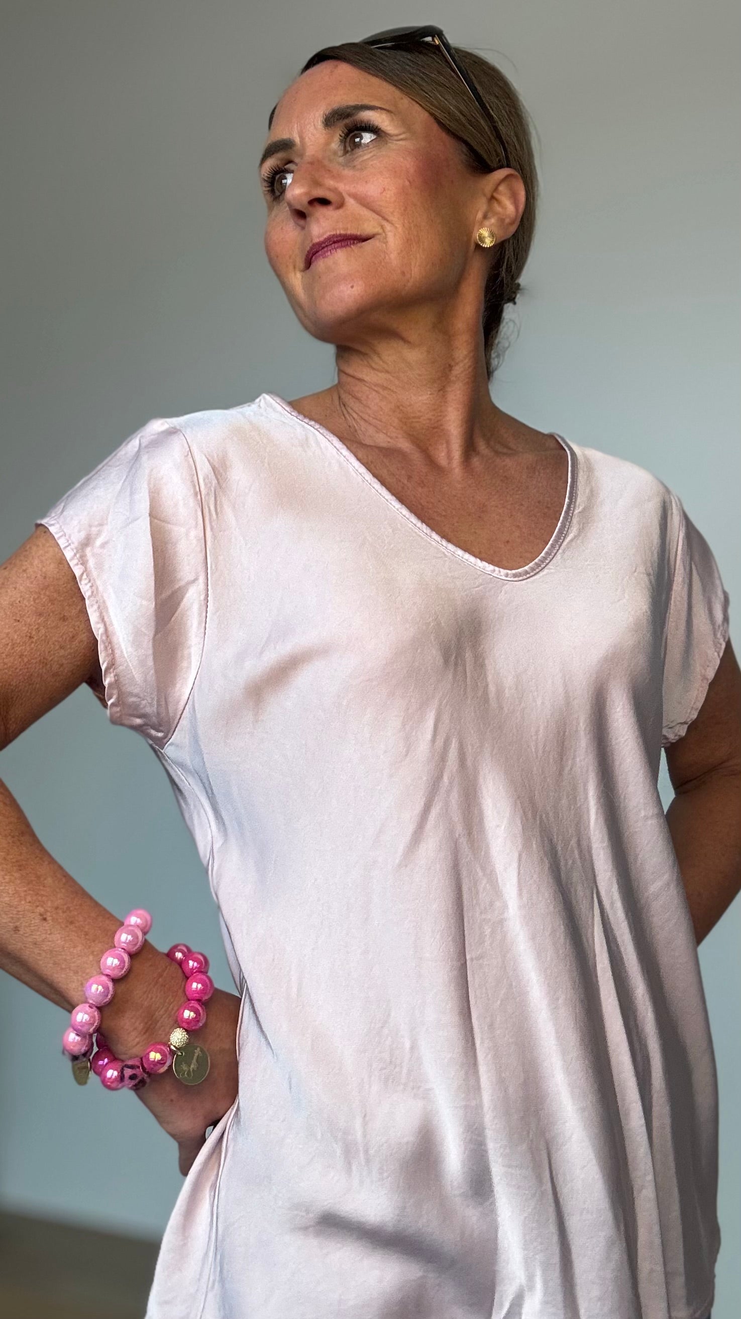 Fließendes Oberteil aus 100% Viskose mit dezentem Glanz. Die Satin Glow Blouse hat kurze Ärmel, einen sanften V-Ausschnitt vorne und hinten und eine luftige Passform. Mit einer Länge von ca. 62 cm und einer Breite von ca. 50 cm passt sie schmalen Kleidergrößen 34–40. Perfekt kombinierbar mit Jeans, Röcken, Cardigans und Blazern für einen stilvollen Look.