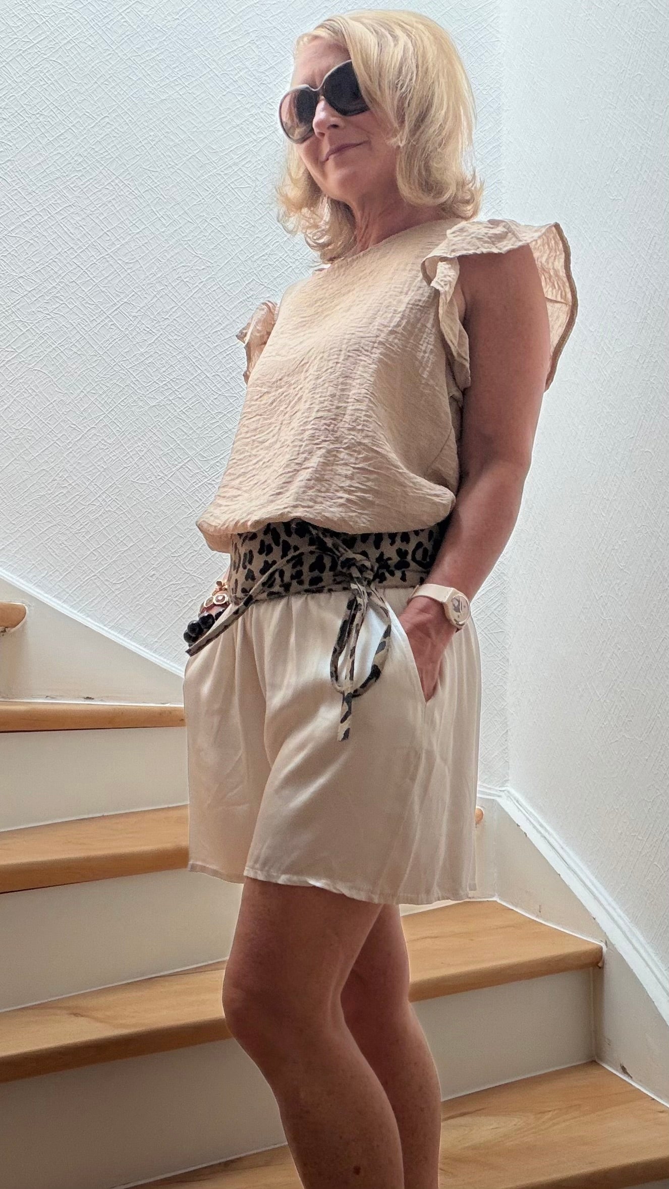 Eisweiße Shorts aus fließender Viskose mit weitem Bein und elastischem Bund mit dekorativer Zierschleife. Der lockere Schnitt sorgt für eine feminine, fast rockähnliche Silhouette. Mit praktischen Eingriffstaschen und einer Länge von ca. 39 cm. Onesize passend für Größe 34–40. Ideal für elegante Sommerlooks, Urlaub und Alltag.
