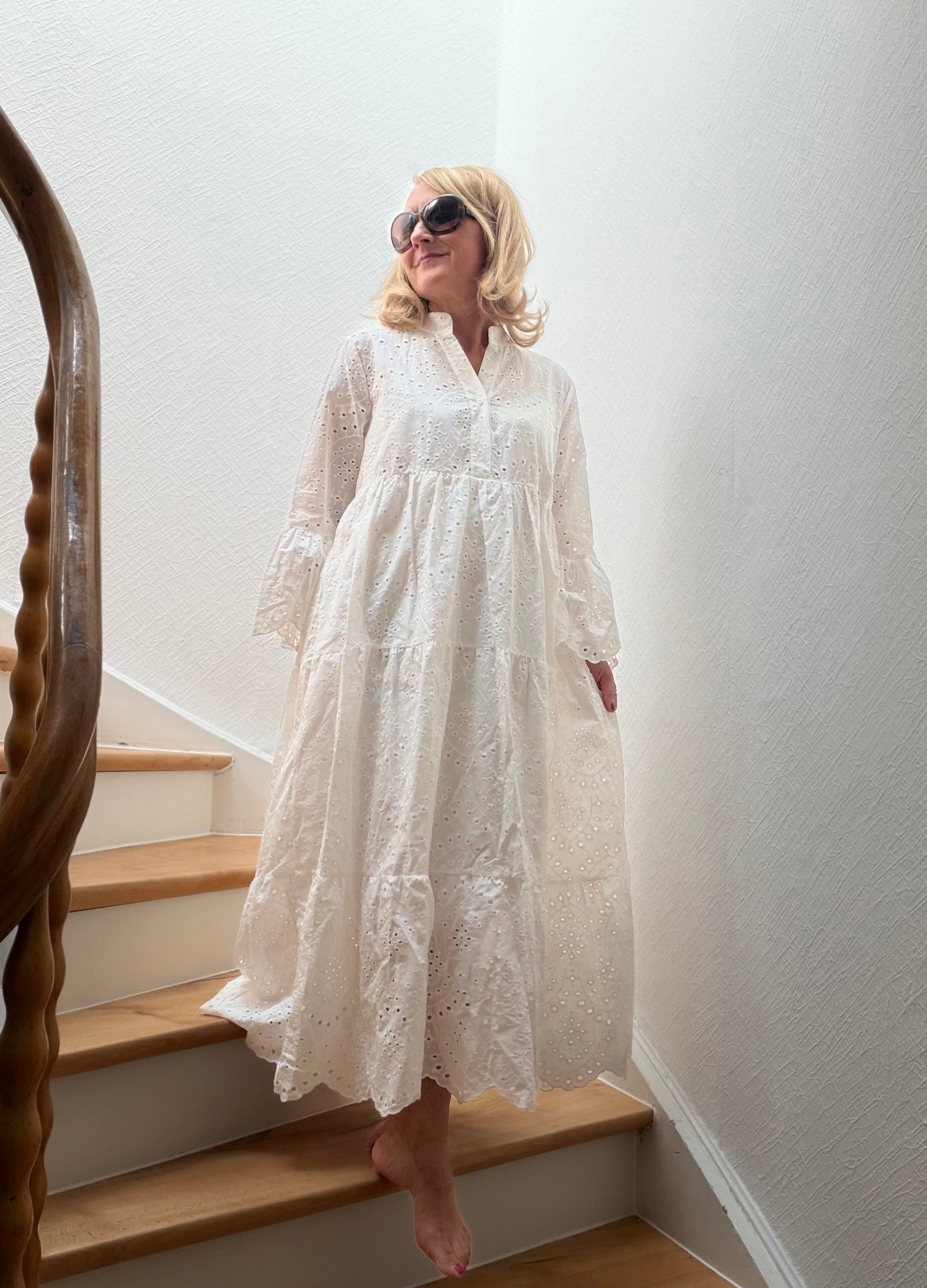 Weißes Maxi-Kleid aus 100 % Baumwolle mit feiner Broderie Anglaise, gestufter Silhouette und trompetenförmigen Ärmeln. Zeitloser Sommerklassiker mit femininer Leichtigkeit – auch wunderschön für Petite-Frauen.