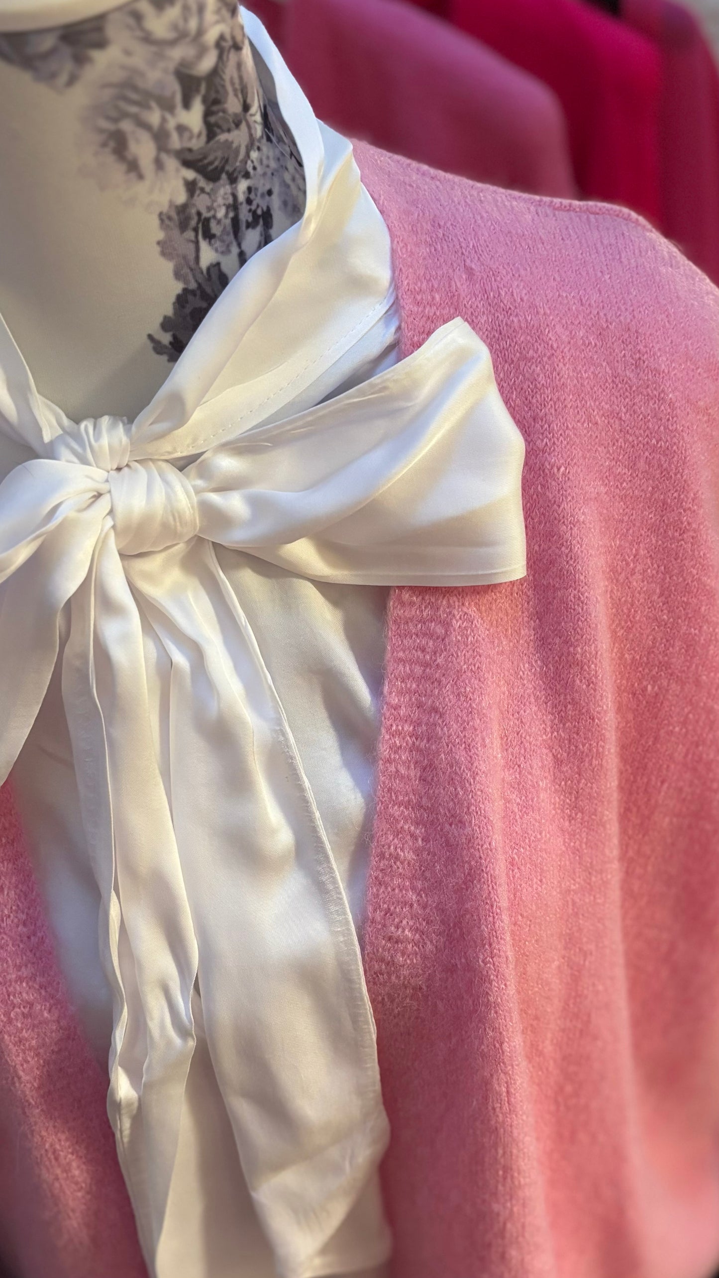 Weiße Schluppenbluse aus 100 % Viskose, gerade geschnitten, mit einer großzügigen Schleife am Hals, die gebunden oder offen getragen werden kann. Langärmlig mit Gummibund am Abschluss, durchgehende Knopfleiste und vielseitig kombinierbar – ideal unter Pullis, Cardigans oder ärmellosen Kleidern. Perfekt für Größen 34-42.