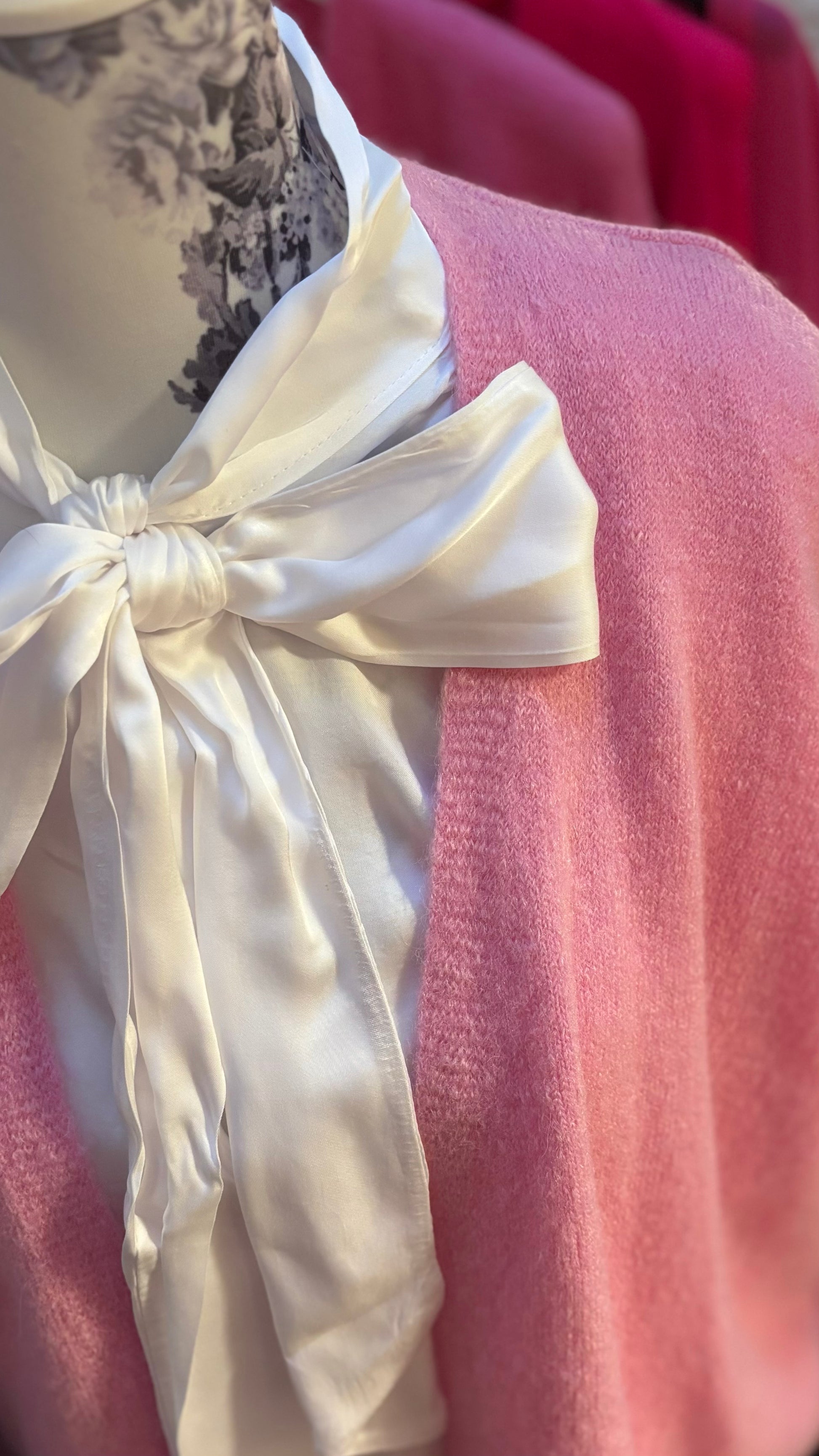 Weiße Schluppenbluse aus 100 % Viskose, gerade geschnitten, mit einer großzügigen Schleife am Hals, die gebunden oder offen getragen werden kann. Langärmlig mit Gummibund am Abschluss, durchgehende Knopfleiste und vielseitig kombinierbar – ideal unter Pullis, Cardigans oder ärmellosen Kleidern. Perfekt für Größen 34-42.